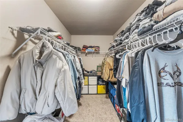 a view of walk in closet with clothes and shoes