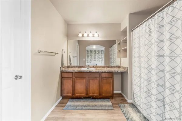a bathroom with a granite countertop sink and a mirror