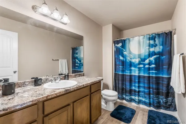 a bathroom with a granite countertop toilet sink and mirror