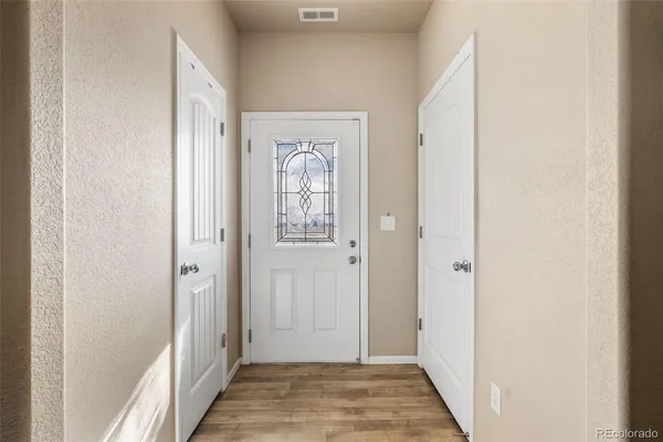 a view of a hallway with wooden floor