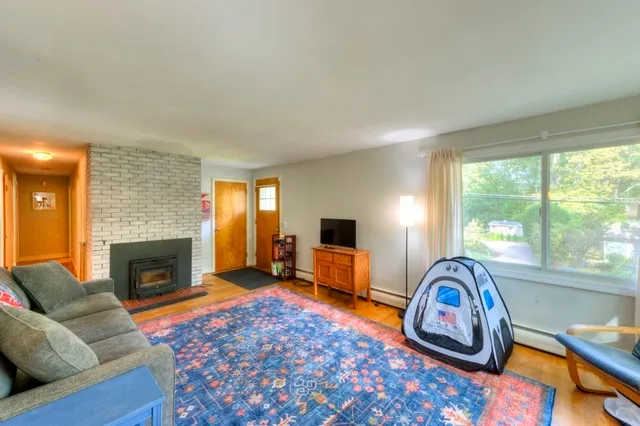 a living room with furniture a fireplace and a window