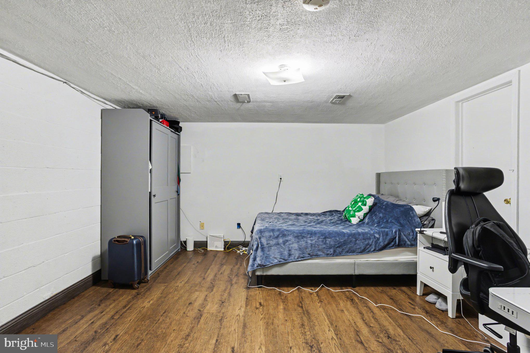 216 Scott Street Baltimore, MD 21230 - Photo 23 of 27 a bedroom with a bed and wooden floor