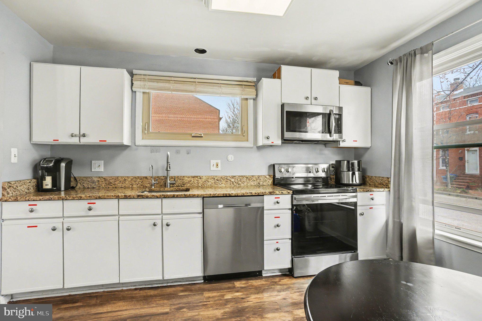 216 Scott Street Baltimore, MD 21230 - Photo 10 of 27 a kitchen with stainless steel appliances granite countertop a stove a sink and white cabinets