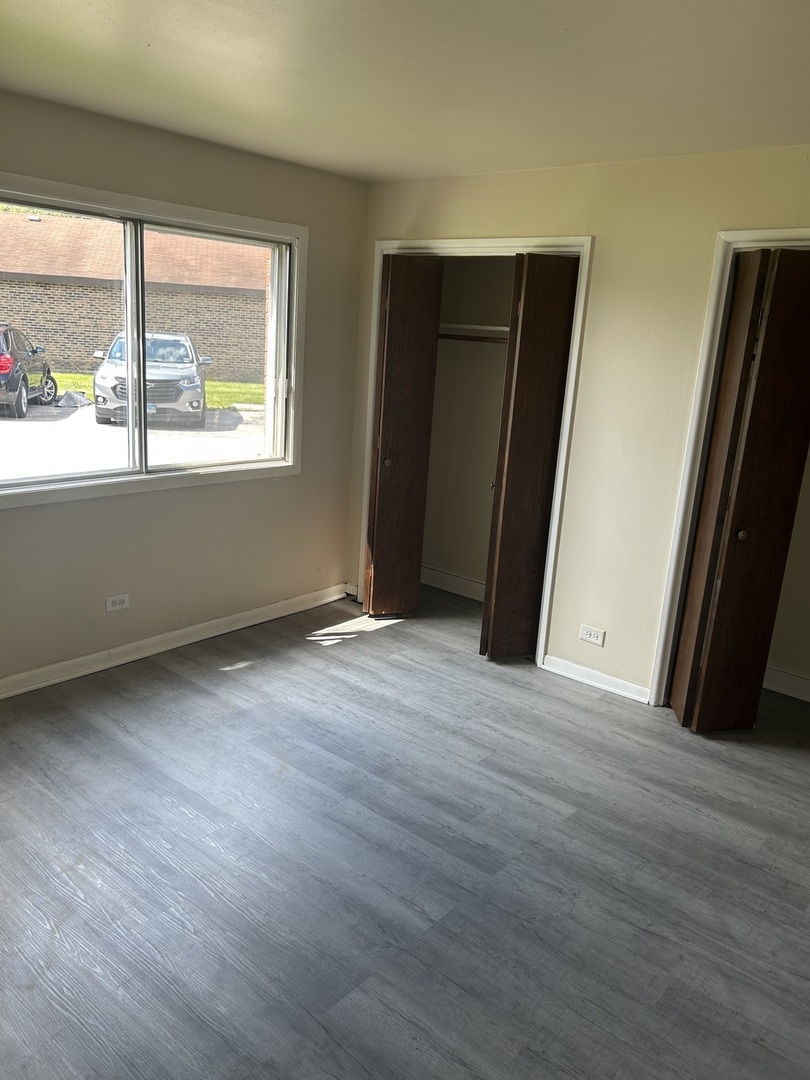 12620 South Alpine Drive, Unit 4 Alsip, IL 60803 - Photo 3 of 13 an empty room with wooden floor and windows