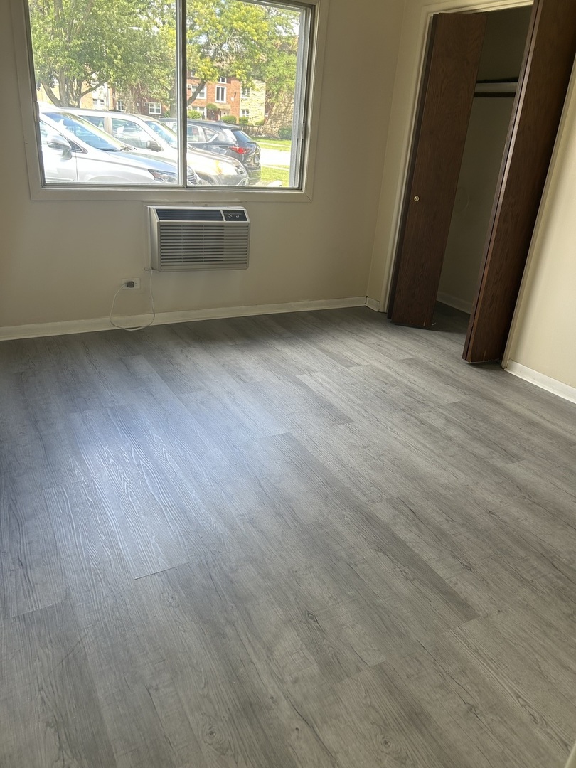 12620 South Alpine Drive, Unit 4 Alsip, IL 60803 - Photo 4 of 13 an empty room with wooden floor and windows