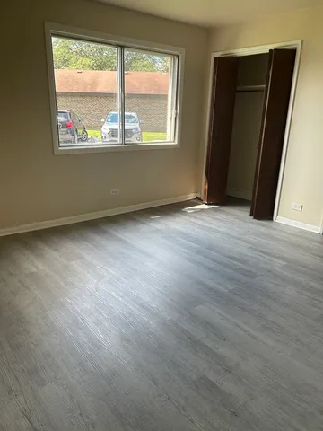 an empty room with wooden floor and a window