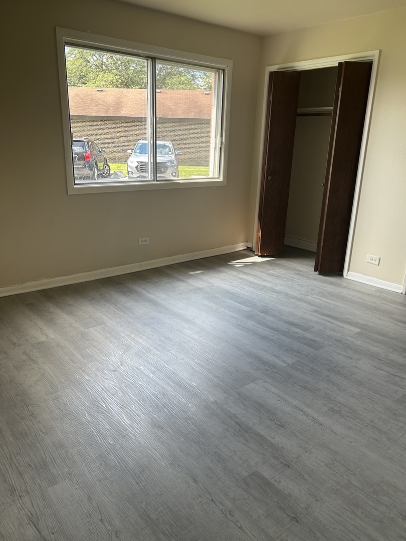 12620 South Alpine Drive, Unit 4 Alsip, IL 60803 - Photo 5 of 13 an empty room with wooden floor and a window