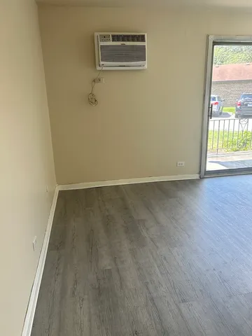 a view of a room with wooden floor and a window