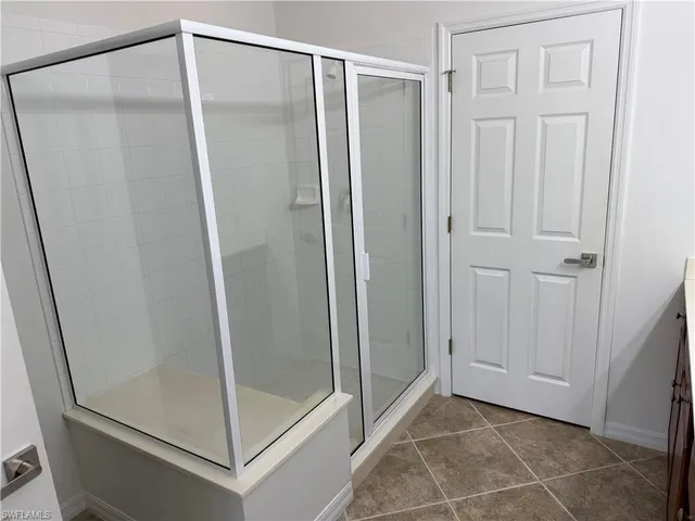 a bathroom with a sink double vanity granite tub and a mirror