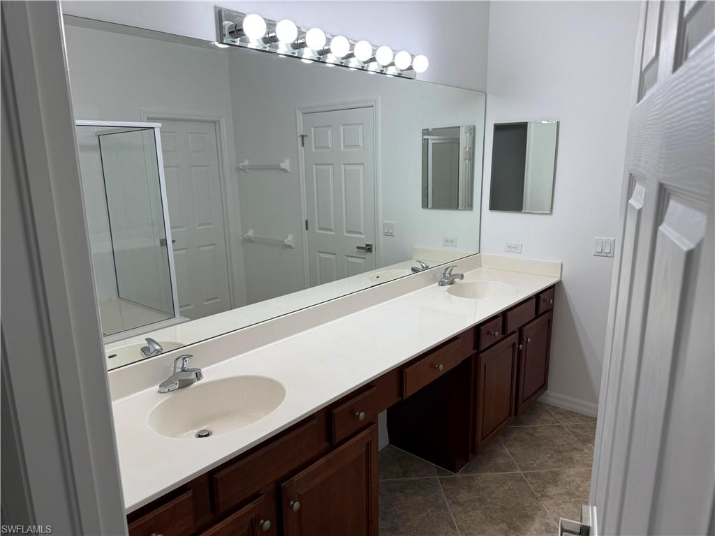 1345 Henley Street, Unit 705 Naples, FL 34105 - Photo 10 of 16 a bathroom with a sink double vanity granite tub and a mirror