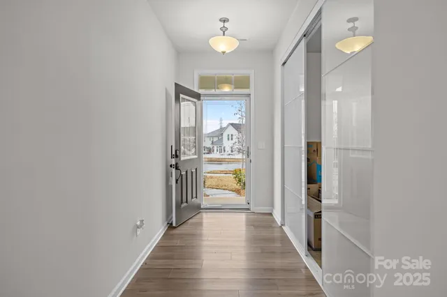 a view of a hallway with wooden floor and a living room