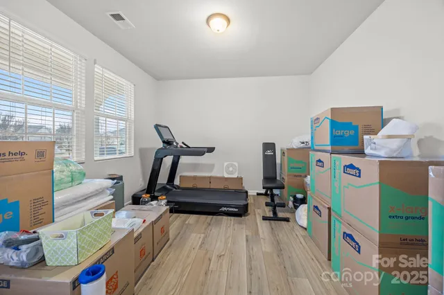 a room with furniture a rug toys and windows