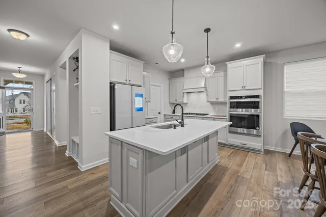a kitchen with kitchen island a sink stove and refrigerator