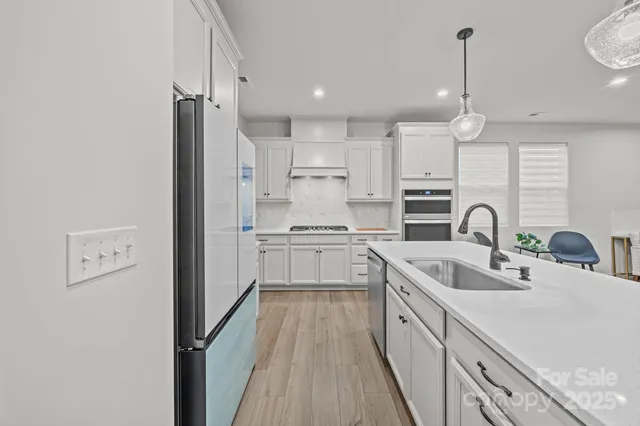 a kitchen with white cabinets stainless steel appliances and a sink