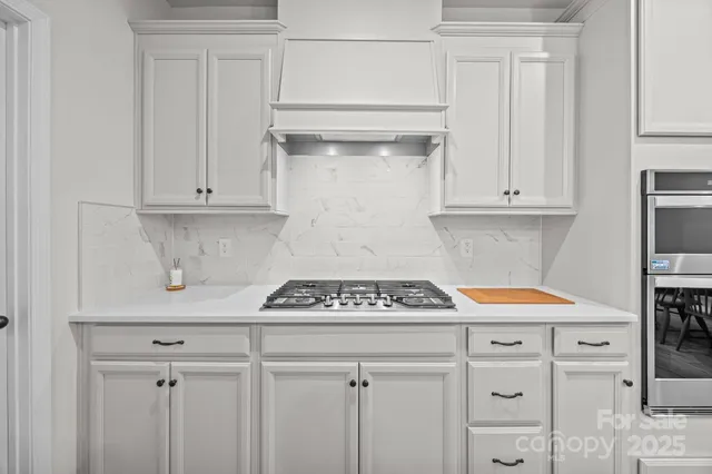 a kitchen with white cabinets and white appliances