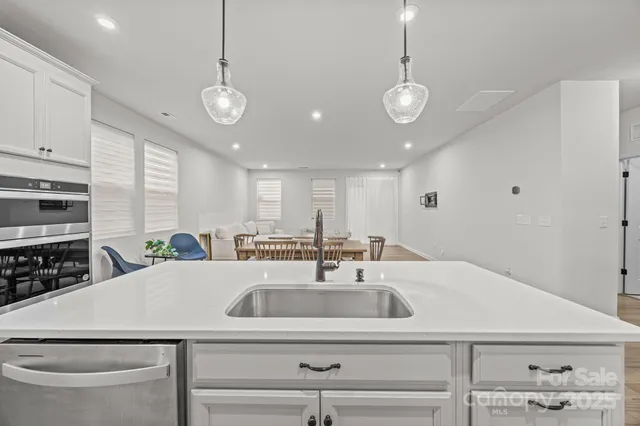 a kitchen with stainless steel appliances a sink a stove a refrigerator and cabinets