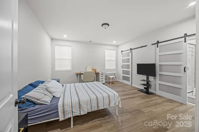 a bedroom with a bed and a flat tv screen on dresser