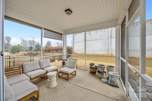 a living room with furniture and floor to ceiling windows