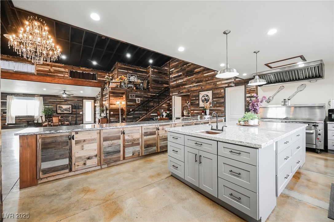 6510 Sunset Drive Caliente, NV 89008 - Photo 25 of 84 Kitchen featuring concrete flooring, gray cabinets, light stone countertops, stove, and a center island with sink
