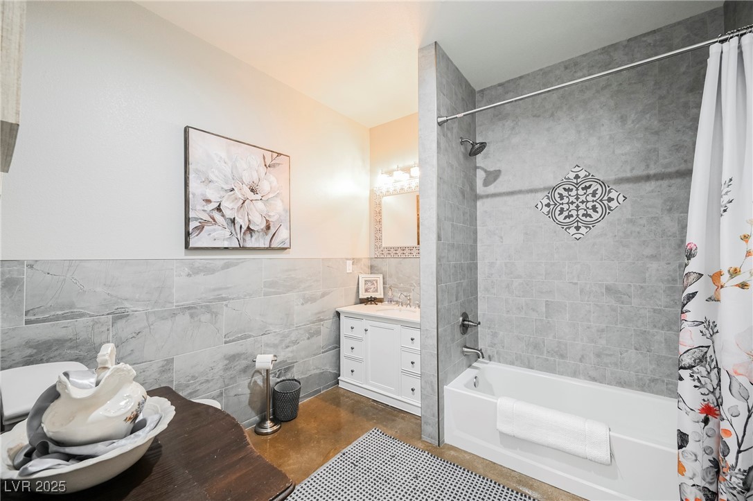 6510 Sunset Drive Caliente, NV 89008 - Photo 28 of 84 Full bathroom with tile walls, shower / bath combo, vanity, finished concrete floors, and a wainscoted wall