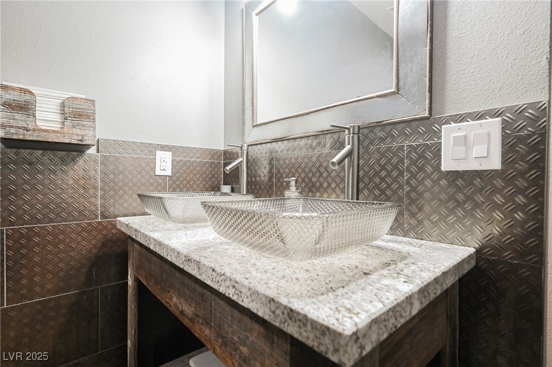 6510 Sunset Drive Caliente, NV 89008 - Photo 33 of 84 Bathroom featuring tile walls, vanity, a textured wall, and wainscoting