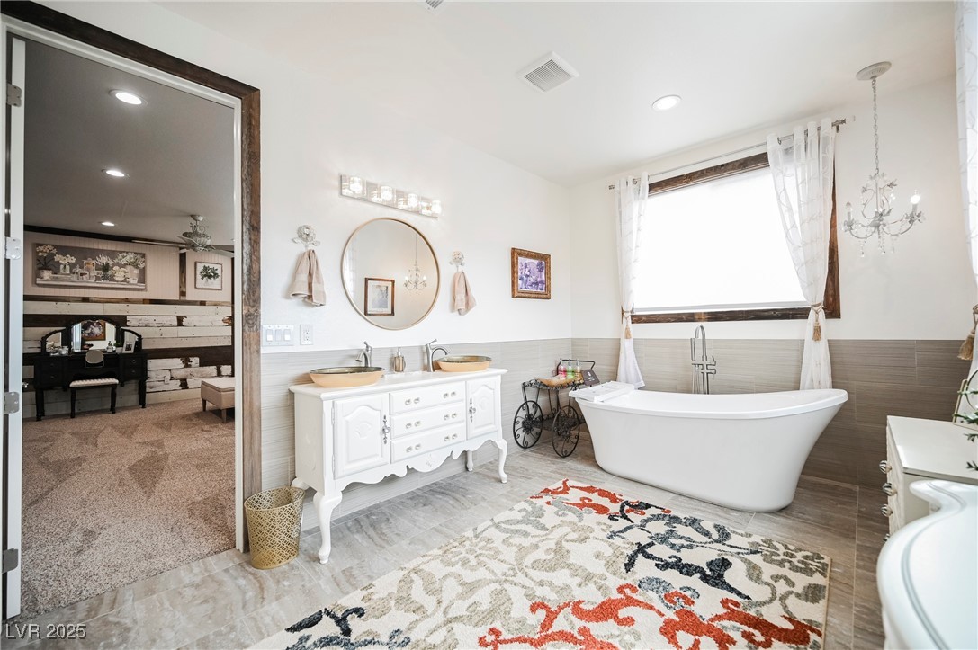 6510 Sunset Drive Caliente, NV 89008 - Photo 41 of 84 Full bathroom featuring double vanity, a freestanding tub, wainscoting, tile walls, and ceiling fan