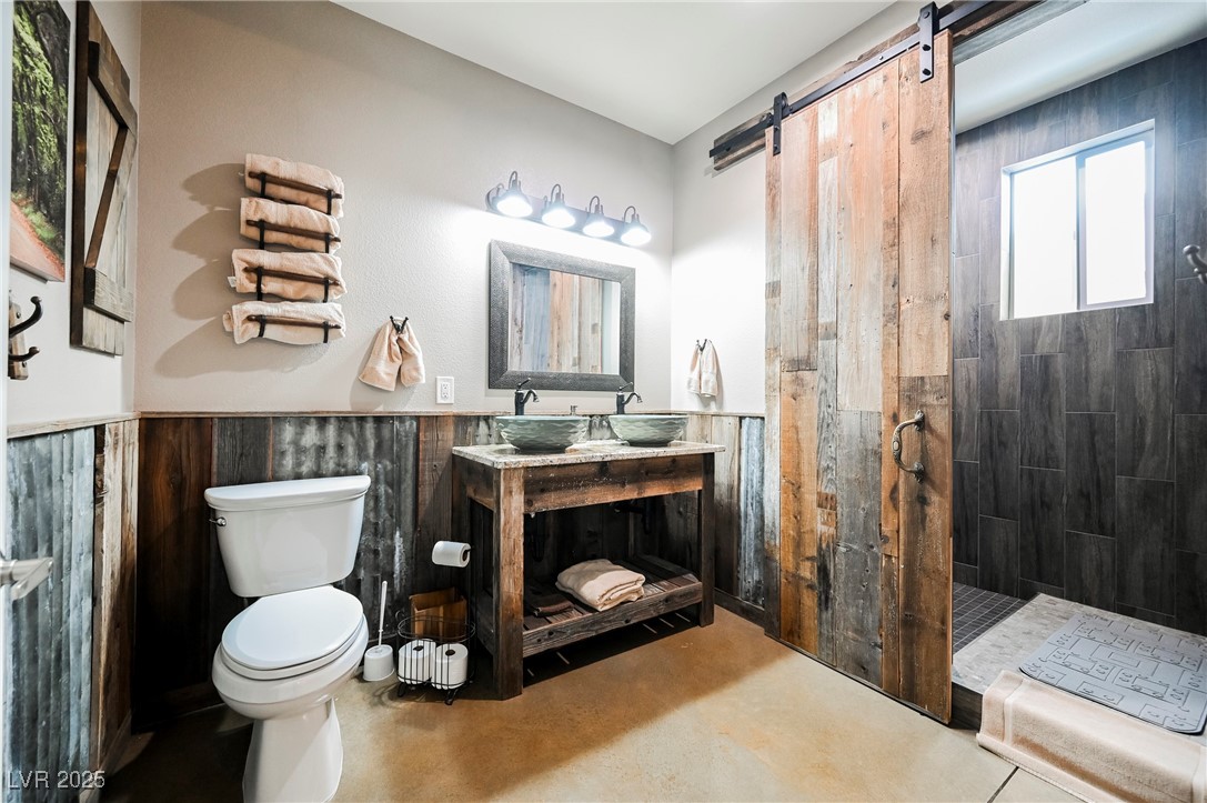 6510 Sunset Drive Caliente, NV 89008 - Photo 50 of 84 Full bath featuring concrete floors, a walk in shower, vanity, and wainscoting