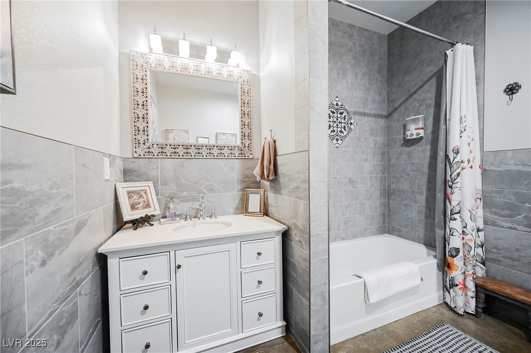 6510 Sunset Drive Caliente, NV 89008 - Photo 71 of 84 Full bathroom with tile walls, shower / bath combo with shower curtain, vanity, and concrete floors