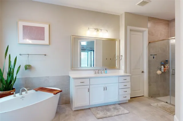 a bathroom with a tub sink and mirror