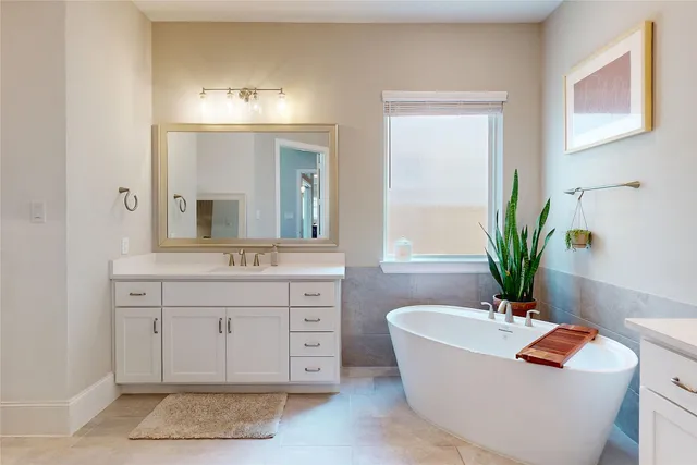 a bath tub sitting in a bathroom and mirror