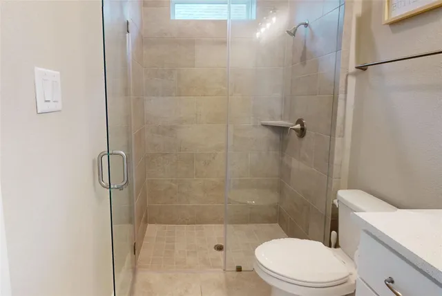 a bathroom with a toilet and a shower