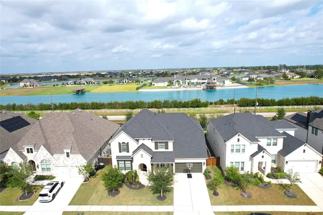an aerial view of a city with lots of residential buildings and lake view in back