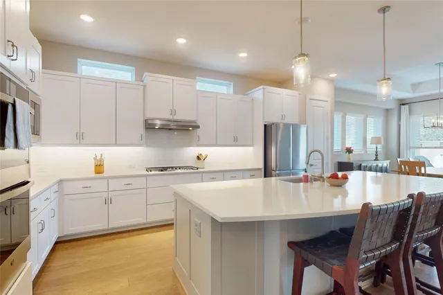 a large kitchen with kitchen island a sink table and chairs