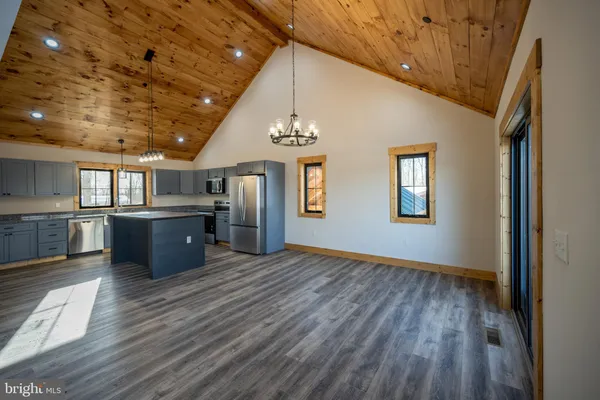 a view of an empty room with wooden floor fireplace and a window