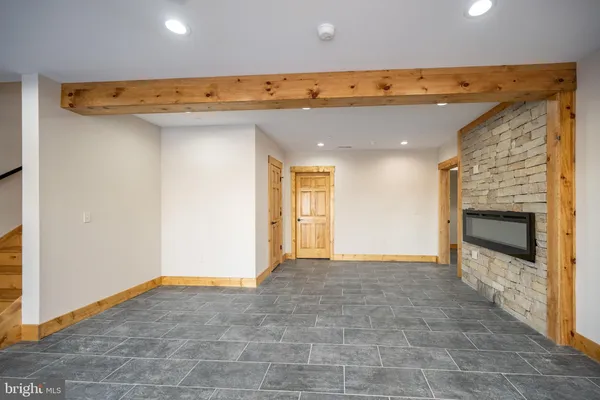 a view of an empty room with window and wooden floor