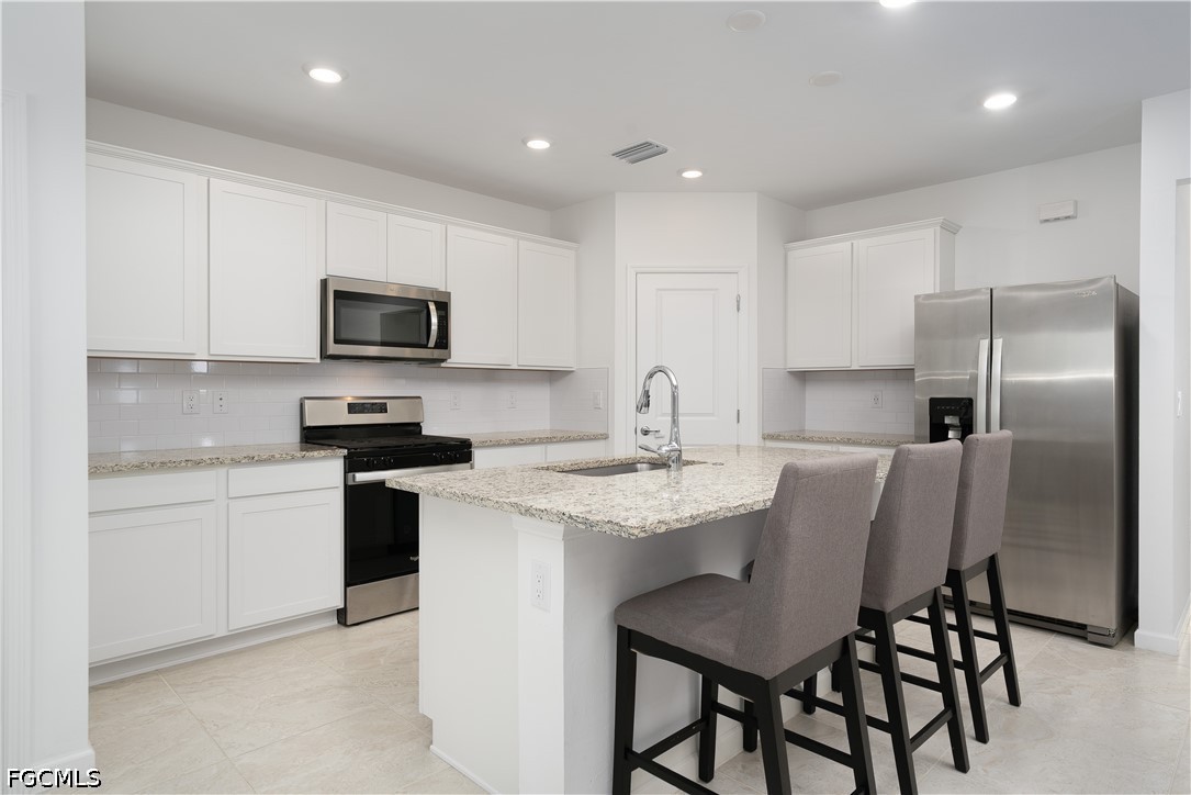 42428 Cascade Drive Punta Gorda, FL 33982 - Photo 5 of 47 a kitchen with kitchen island granite countertop a sink stove and refrigerator