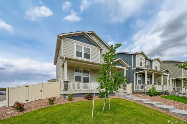 a front view of a house with a yard and trees