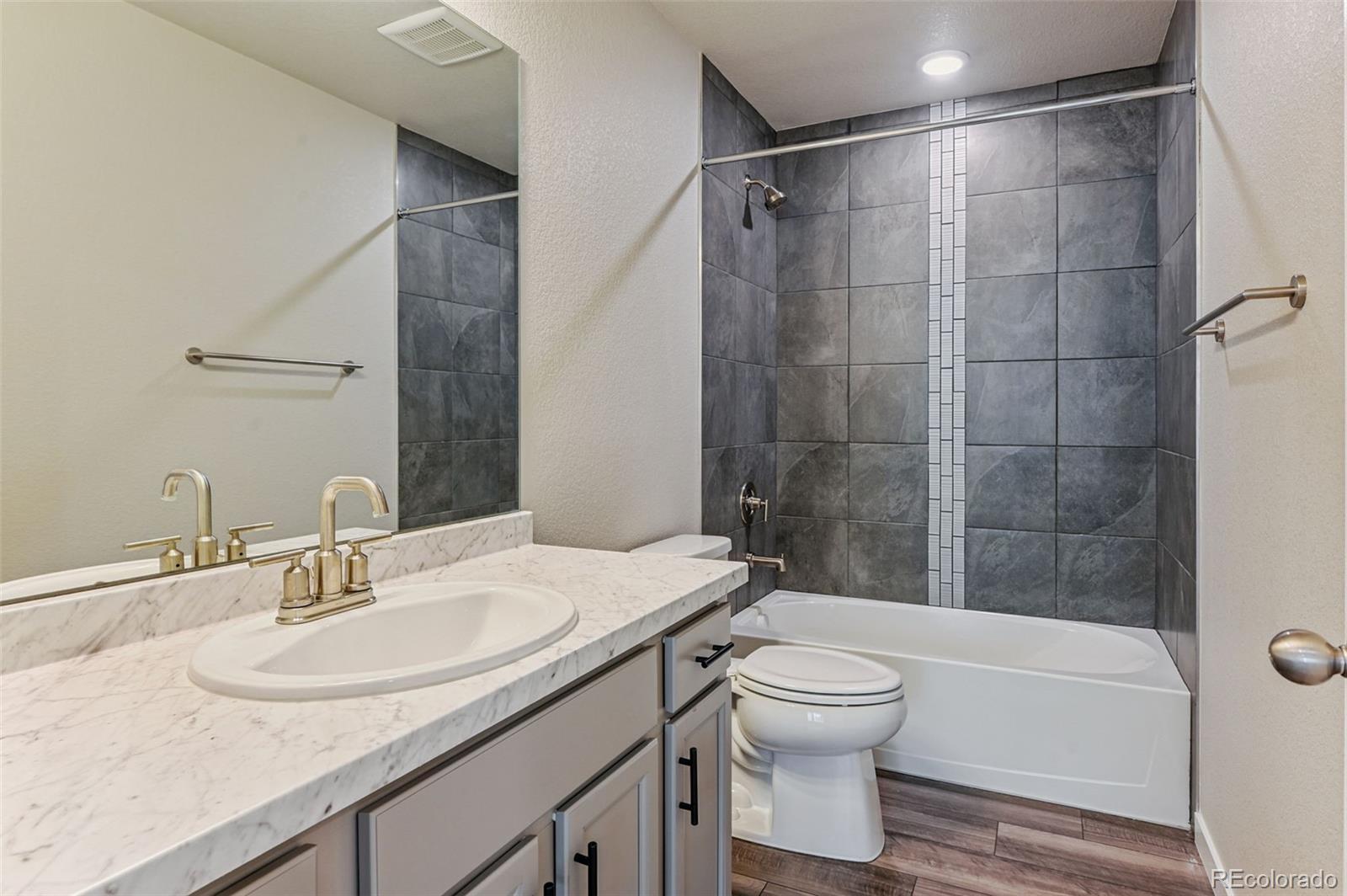 8206 Turtle Lake Way Colorado Springs, CO 80925 - Photo 12 of 27 a bathroom with a granite countertop sink toilet a mirror and shower