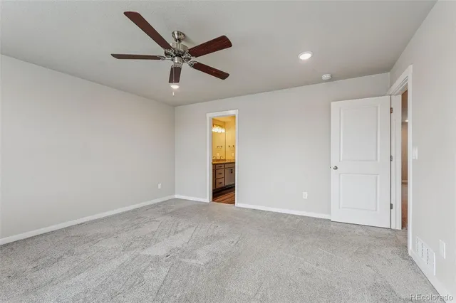 a view of an empty room with ceiling fan