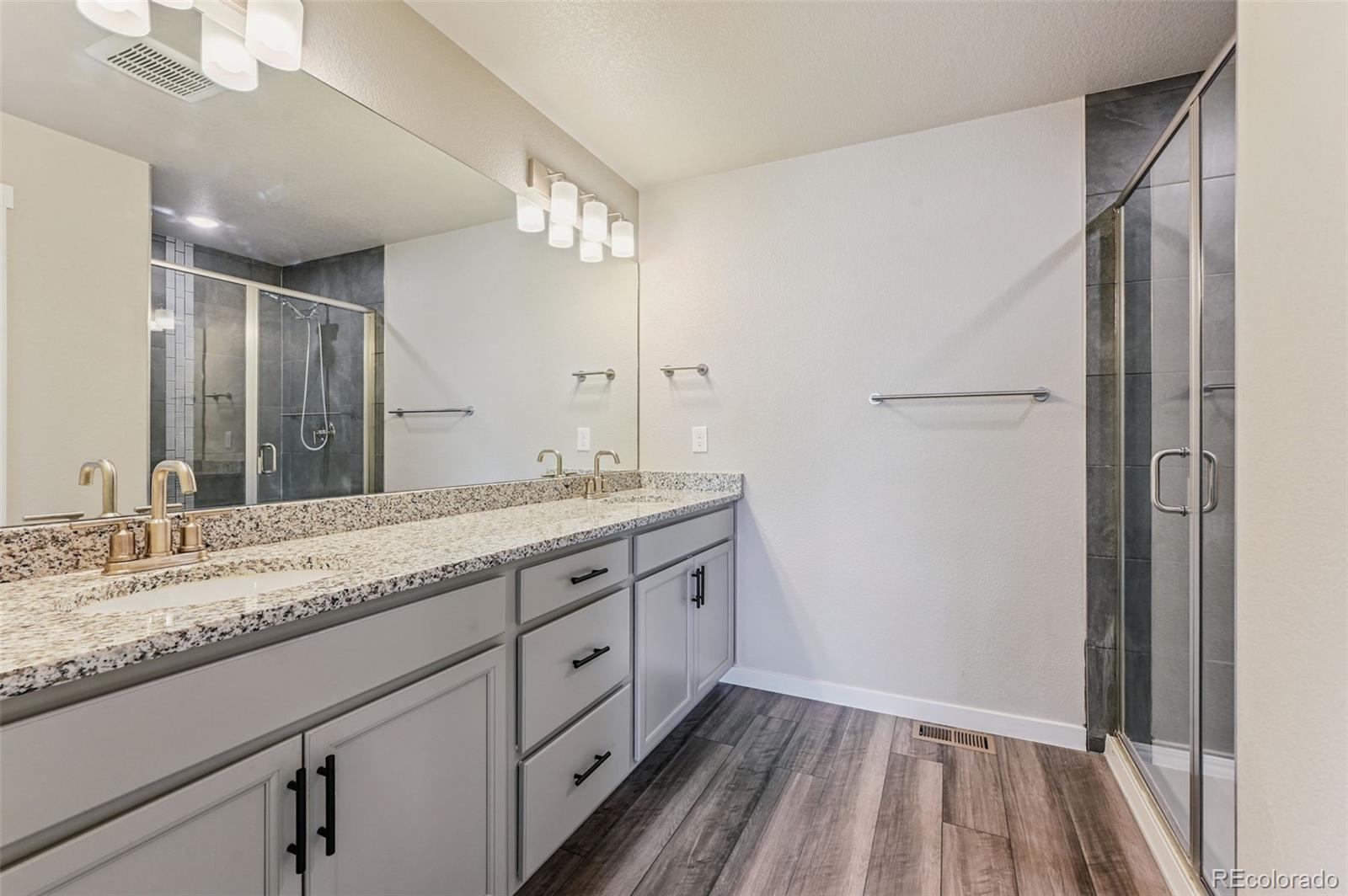 8206 Turtle Lake Way Colorado Springs, CO 80925 - Photo 22 of 27 a bathroom with a granite countertop double vanity sink and mirror