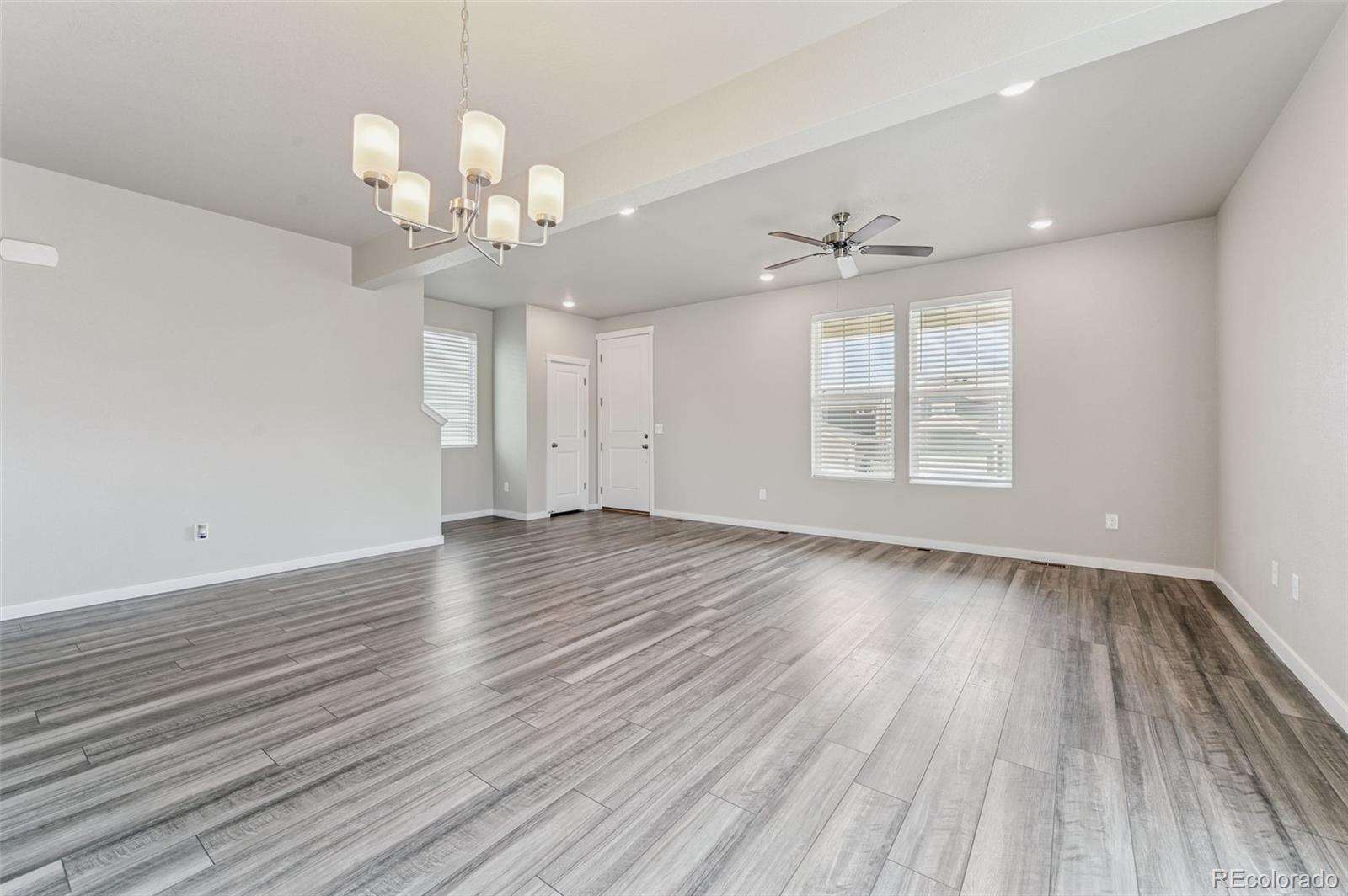 8206 Turtle Lake Way Colorado Springs, CO 80925 - Photo 3 of 27 an empty room with wooden floor and windows