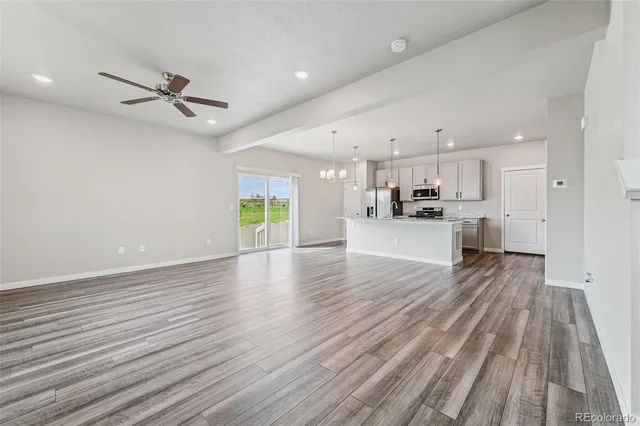 a view of a kitchen with a sink and dishwasher a refrigerator with wooden floor