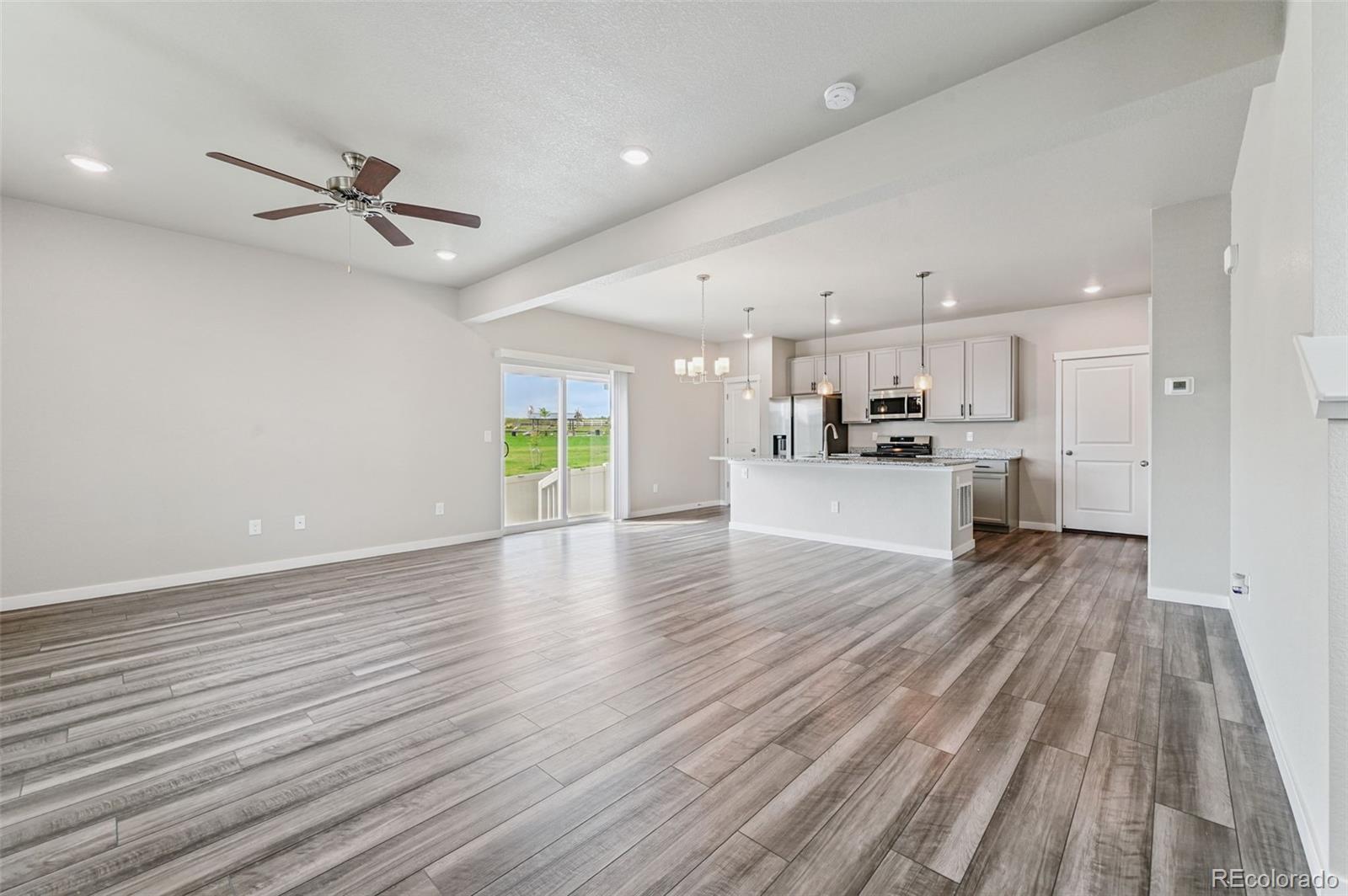 8206 Turtle Lake Way Colorado Springs, CO 80925 - Photo 4 of 27 a view of a kitchen with a sink and dishwasher a refrigerator with wooden floor