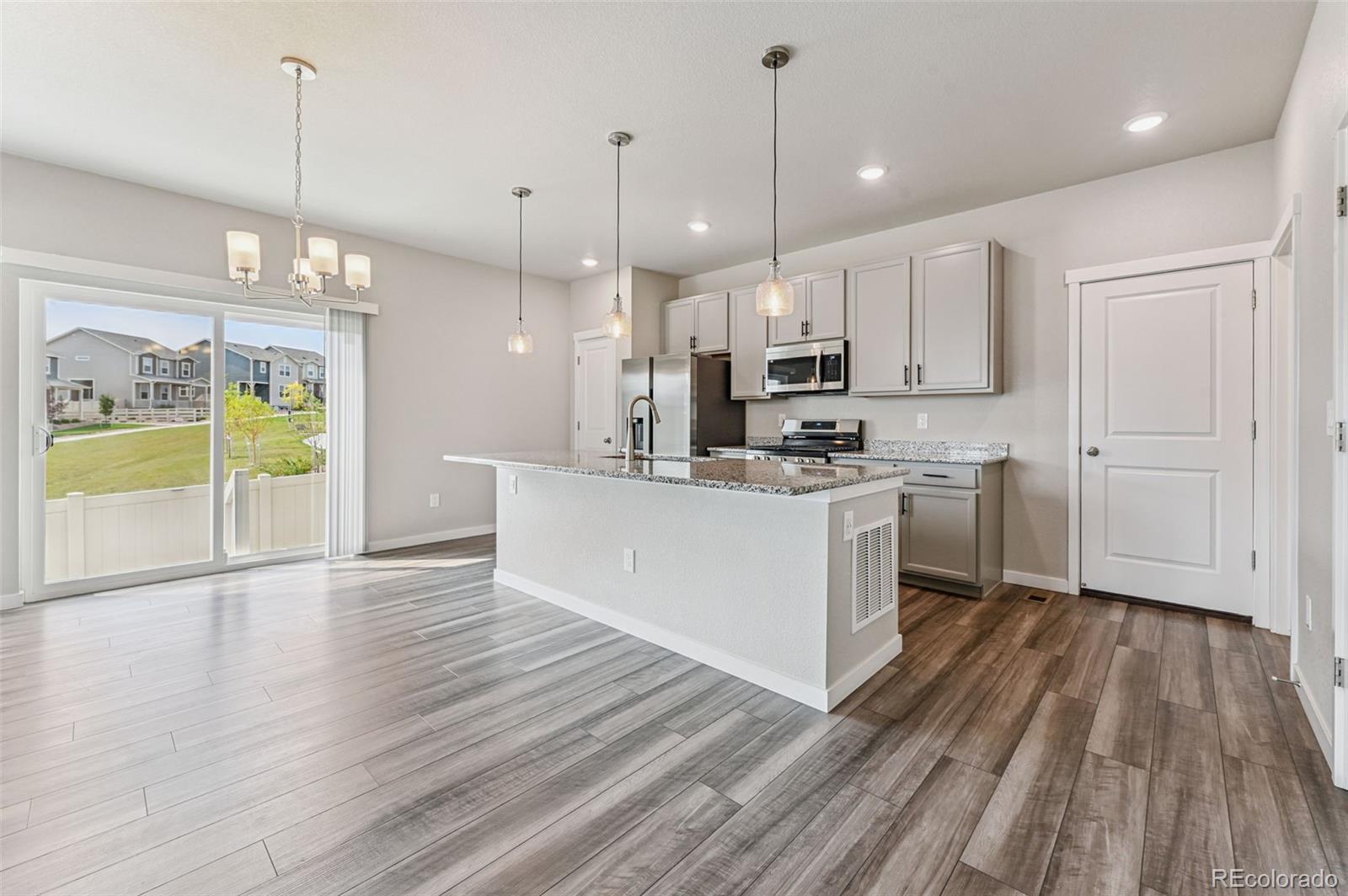8206 Turtle Lake Way Colorado Springs, CO 80925 - Photo 6 of 27 a kitchen with kitchen island a white counter space appliances and cabinets