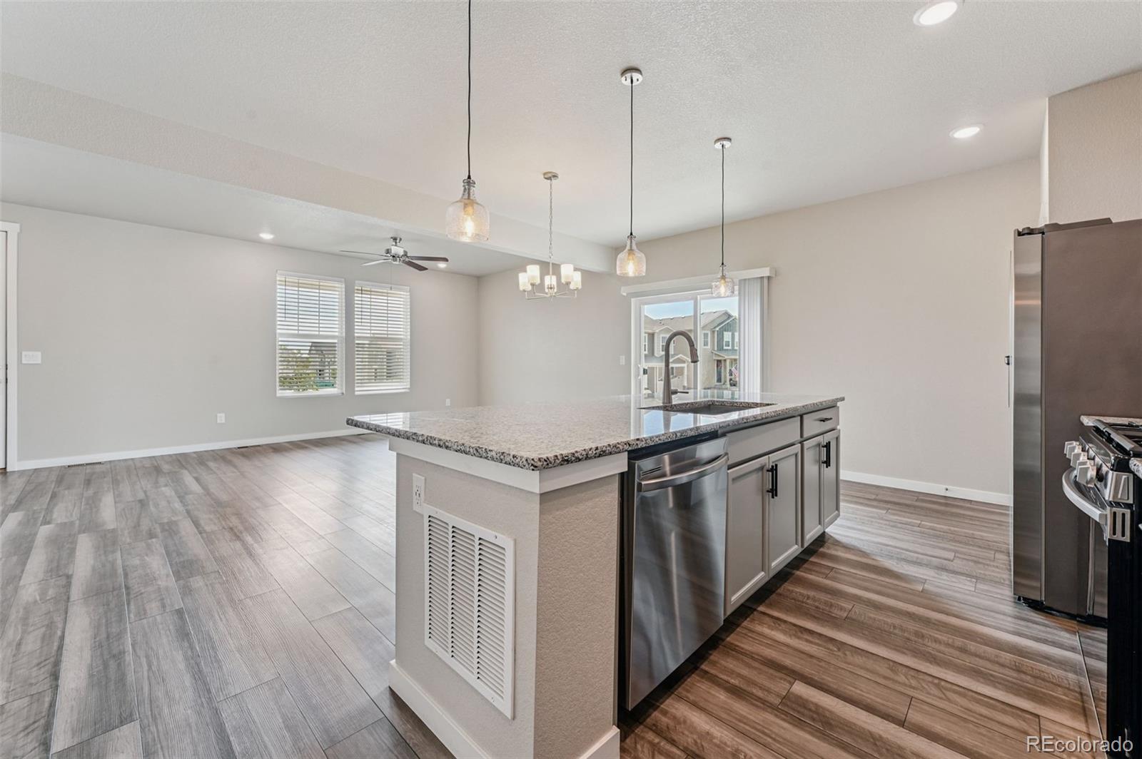 8206 Turtle Lake Way Colorado Springs, CO 80925 - Photo 7 of 27 a kitchen with stainless steel appliances granite countertop a sink a stove and a wooden floors