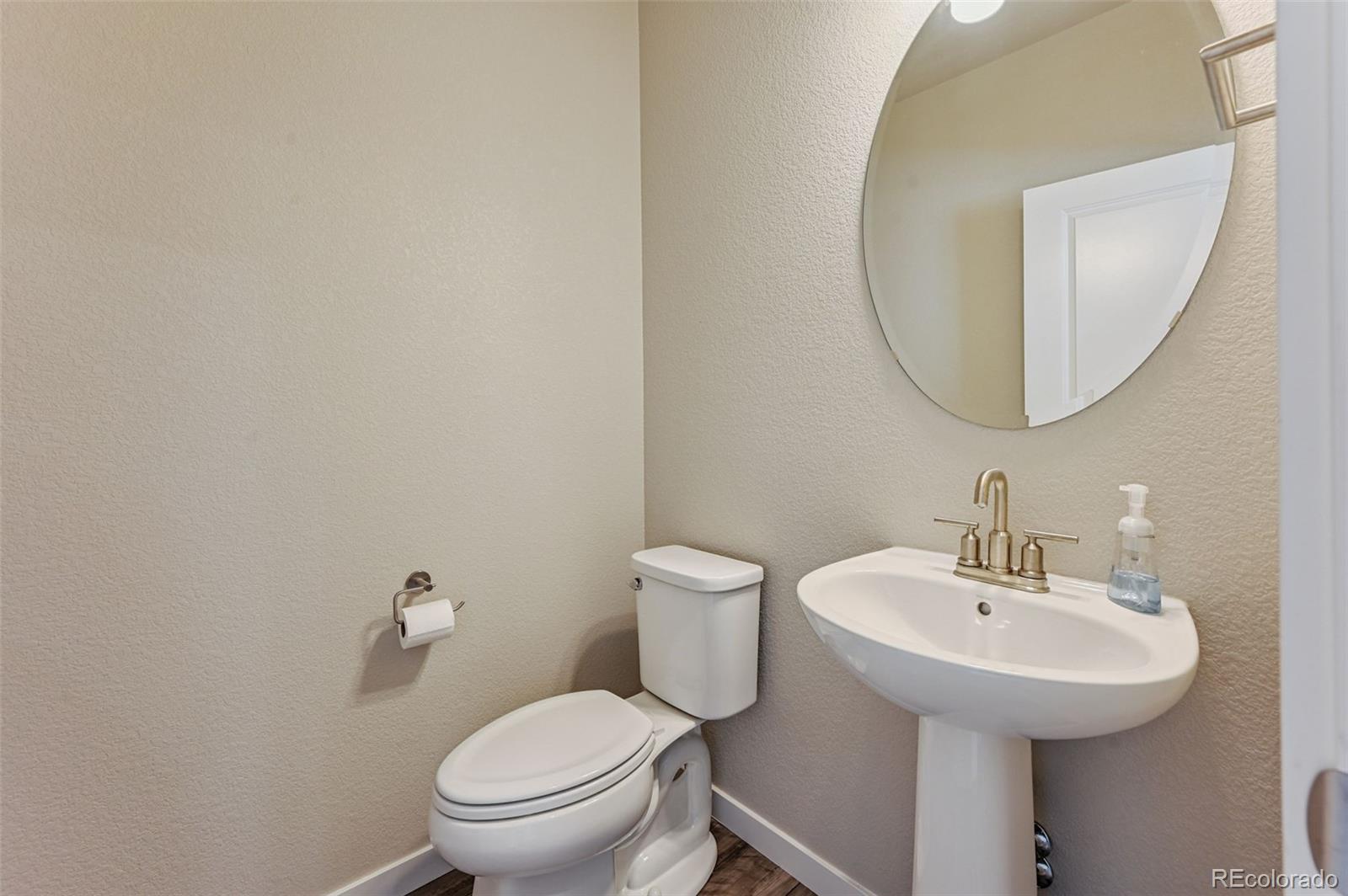 8206 Turtle Lake Way Colorado Springs, CO 80925 - Photo 9 of 27 a bathroom with a toilet a sink and a mirror
