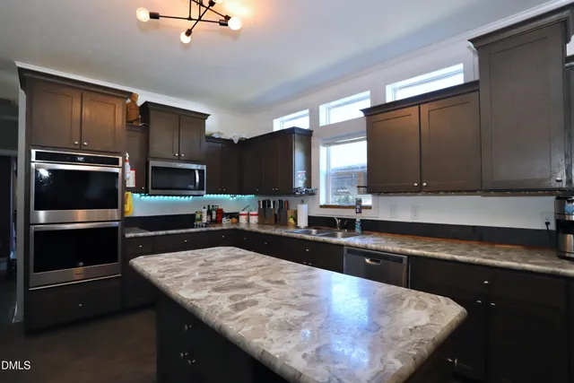 a kitchen with stainless steel appliances wooden cabinets a sink and a stove