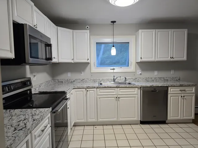 a kitchen with a sink stove and microwave