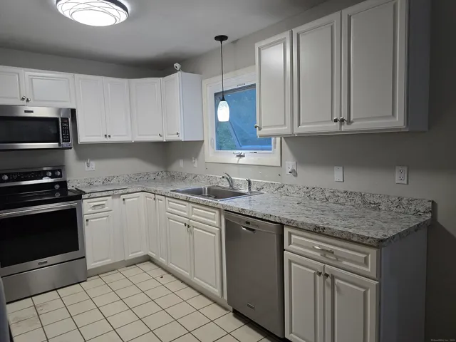 a kitchen with cabinets appliances and a counter space