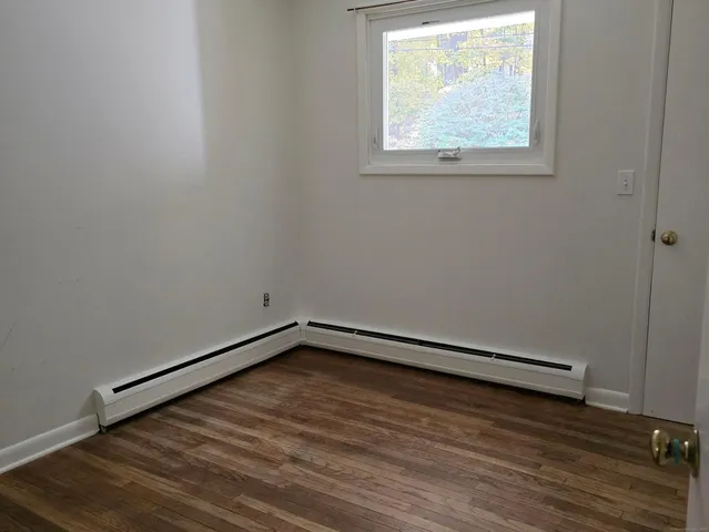 a view of a room with wooden floor and window